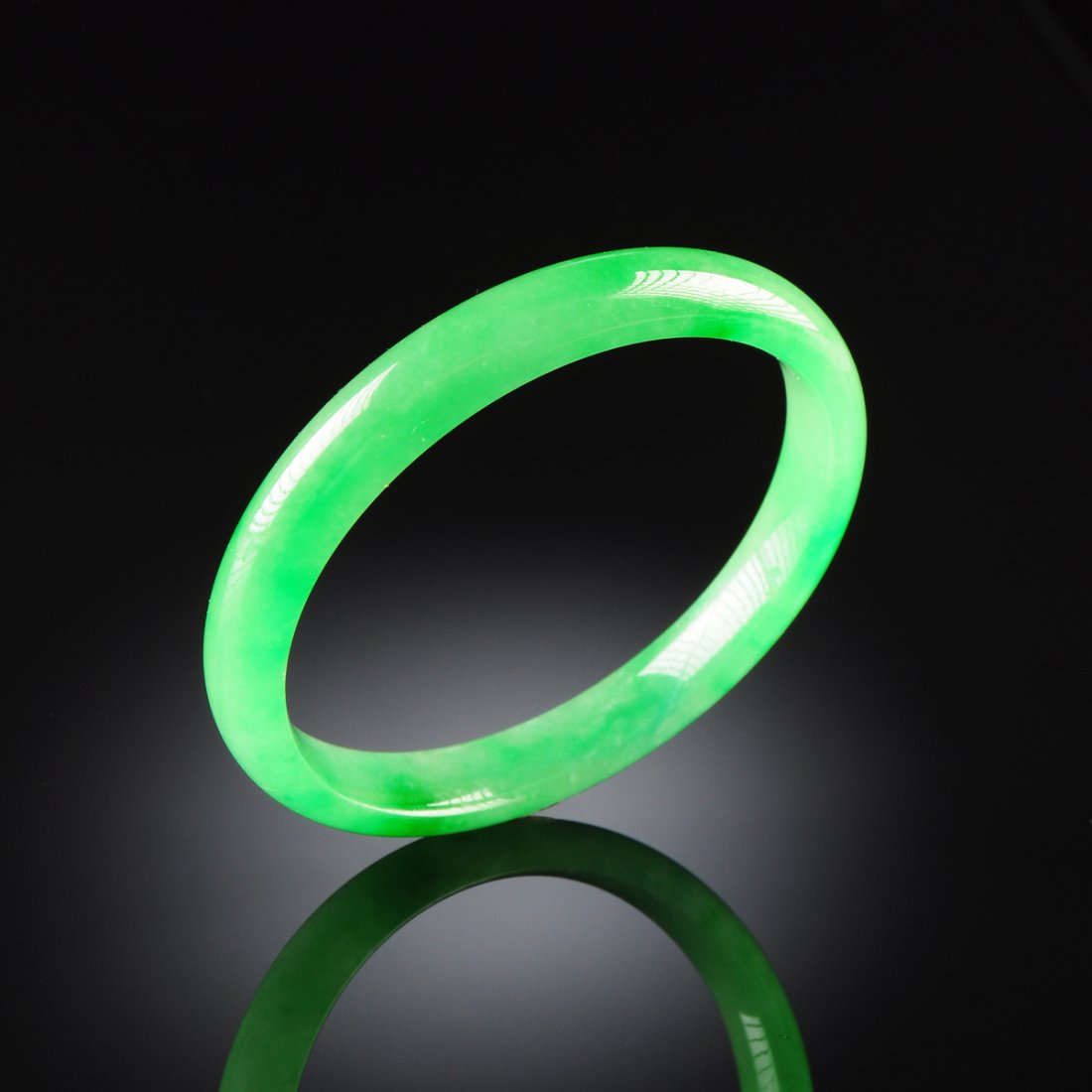A CHINESE APPLE GREEN JADEITE BANGLE BRACELET, MODERN,: A CHINESE APPLE GREEN JADEITE BANGLE BRACELET, MODERN, of traditional circular form, inside diameter: 2 1/4".