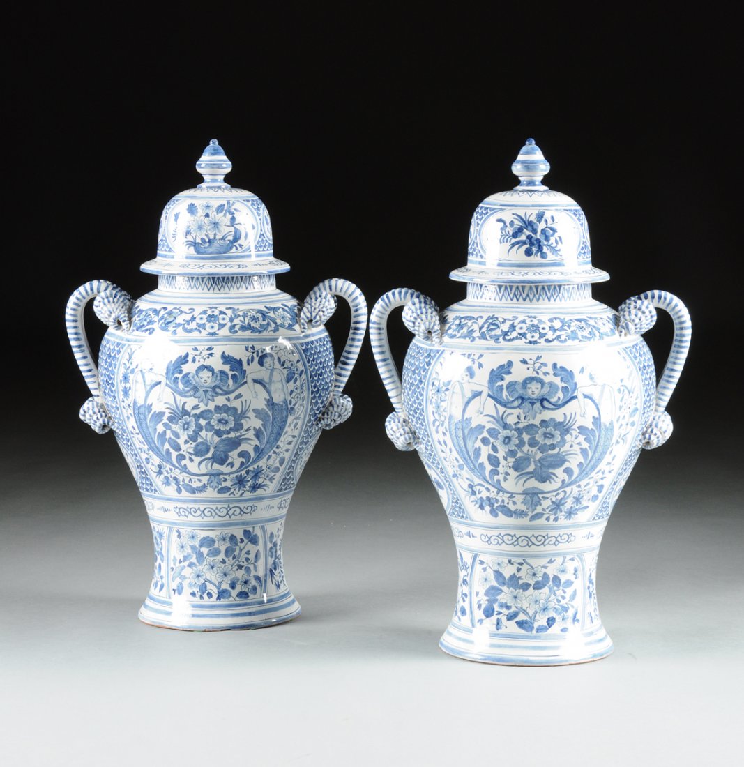 A PAIR OF LARGE FRENCH FAIENCE BLUE AND WHITE PAINTED: A PAIR OF LARGE FRENCH FAIENCE BLUE AND WHITE PAINTED LIDDED VASES, LATE 19TH/EARLY 20TH CENTURY, each of shaped baluster form with sides centering a rectangular reserve depicting Diana the Huntress a