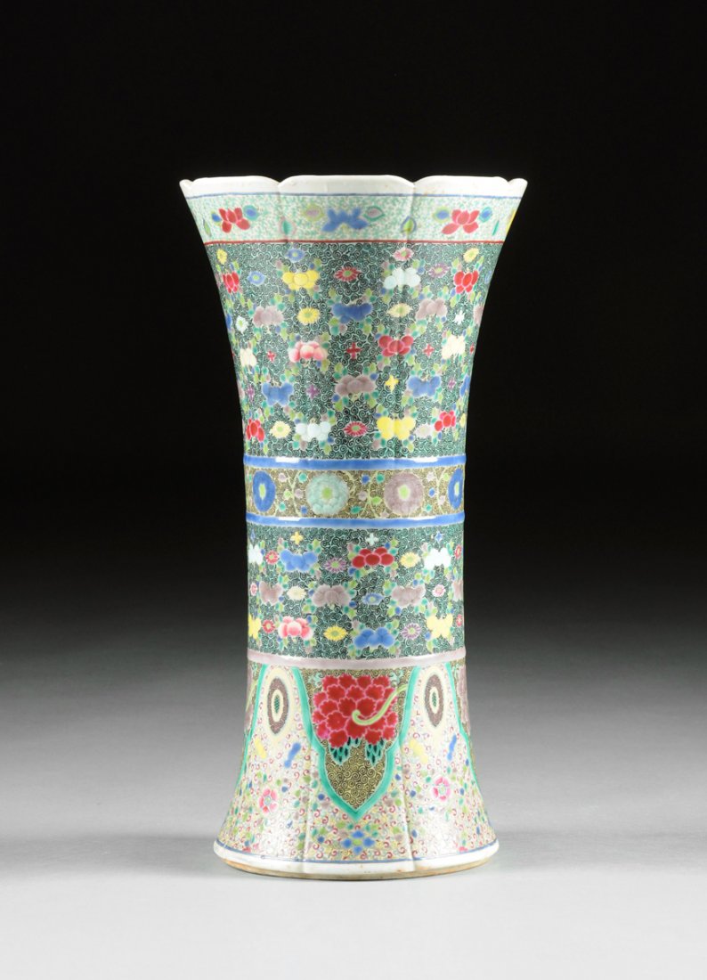 A LARGE UNUSUAL FAMILLE ROSE AND POLYCHROME ENAMELED GU: A LARGE UNUSUAL FAMILLE ROSE AND POLYCHROME ENAMELED GU SHAPED BEAKER VASE, the white slip glazed body with gently lobed sides having a stylized scalloped rim above a collar of variously colored bloom