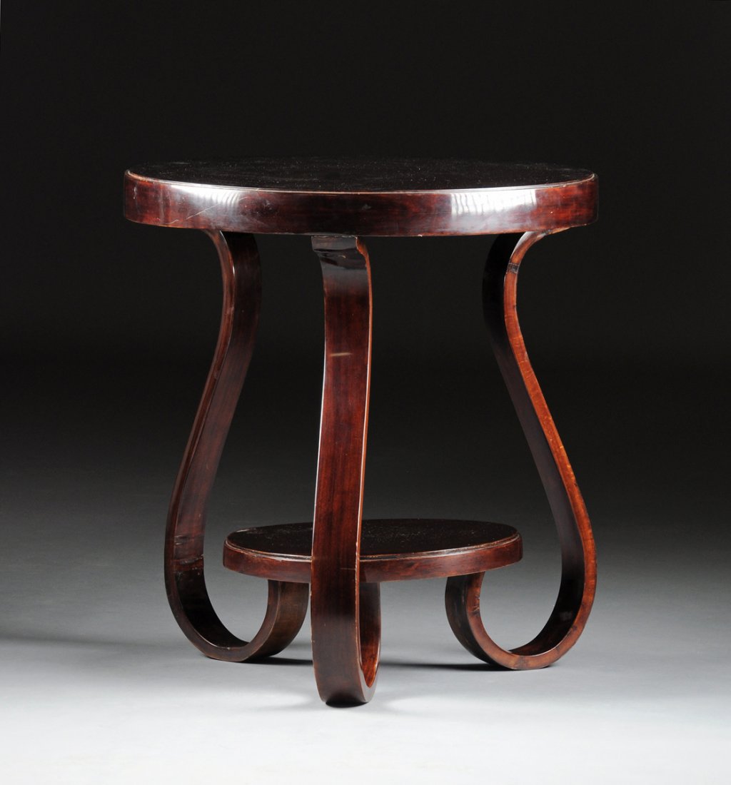 AN ART DECO MAHOGANY SIDE TABLE, CIRCA 1930,: AN ART DECO MAHOGANY SIDE TABLE, CIRCA 1930, with a circular top raised on three shaped flat legs joined by a conforming shelf stretcher. Height: 27" Diameter: 25 1/4"