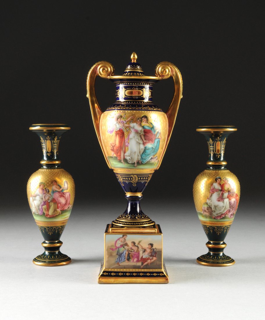 A THREE PIECE MATCHED VIENNA PARCEL GILT AND POLYCHROME: A THREE PIECE MATCHED VIENNA PARCEL GILT AND POLYCHROME PAINTED PORCELAIN VASE GARNITURE, LATE 19TH CENTURY, comprising a pair of diminutive Neoclassical style ovoid vases with sides depicting figures