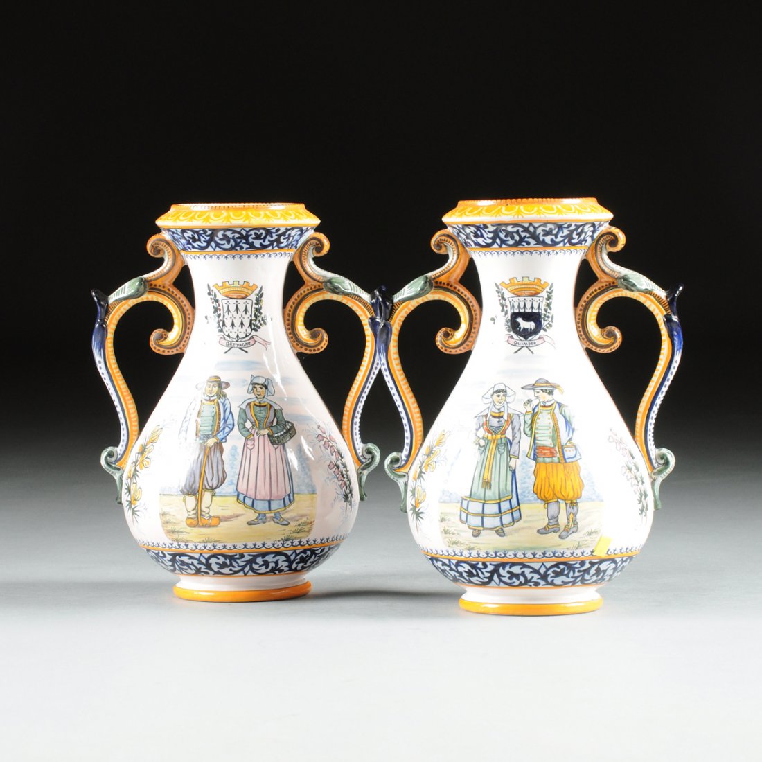 A PAIR OF HENRIOT QUIMPER FAIENCE TWO-HANDLED VASES,: A PAIR OF HENRIOT QUIMPER FAIENCE TWO-HANDLED VASES, FRANCE, LATE 20TH CENTURY, the baluster form vases with addorsed scroll handles, with transfer printed outlined decoration with hand painted colora