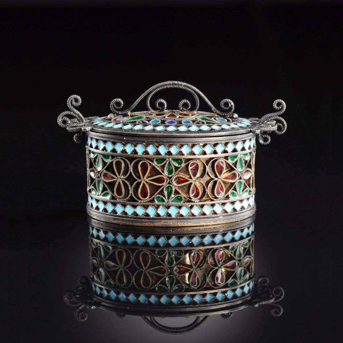 A DAVID ANDERSON NORWEGIAN SILVER GILT AND ENAMEL OVAL: A DAVID ANDERSON NORWEGIAN SILVER GILT AND ENAMEL OVAL COVERED BOX, OSLO, CIRCA 1888-1925, the straight sides with banded green and red enamel stylized floral decoration on gilt ground framed by turqu