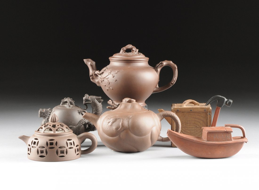 A GROUP OF SIX UNUSUAL YIXING EARTHENWARE TEAPOTS, EACH: A GROUP OF SIX UNUSUAL YIXING EARTHENWARE TEAPOTS, EACH SIGNED, LATE 20TH CENTURY, comprising a tool box form teapot with naturalistically detailed wood plank box body surmounted by a conforming lid w