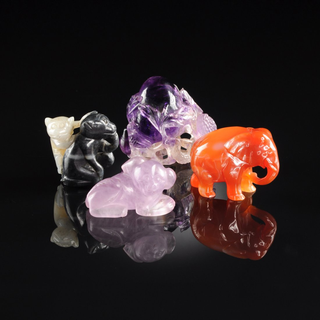 A GROUP OF FOUR CHINESE MINIATURE HARDSTONE ANIMAL AND: A GROUP OF FOUR CHINESE MINIATURE HARDSTONE ANIMAL AND FRUIT CARVINGS, MODERN, comprising a carnelian elephant, height: 1 1/2"; a pale amethyst figure of a recumbent sad eyed cub, length: 1 3/4"; a re