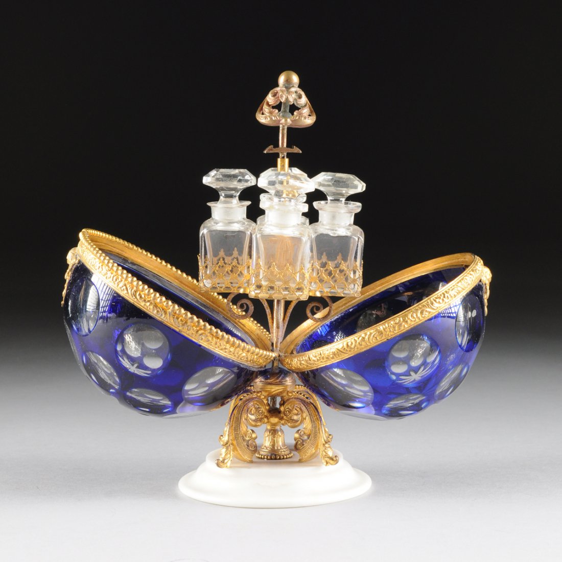 A CONTINENTAL COBALT BLUE CUT TO CLEAR CRYSTAL EGG: A CONTINENTAL COBALT BLUE CUT TO CLEAR CRYSTAL EGG SHAPE MECHANICAL SCENT CASKET, PROBABLY BOHEMIAN, CIRCA 1880, each side with two graduated rings of circular slices centering star mounted in gilt br