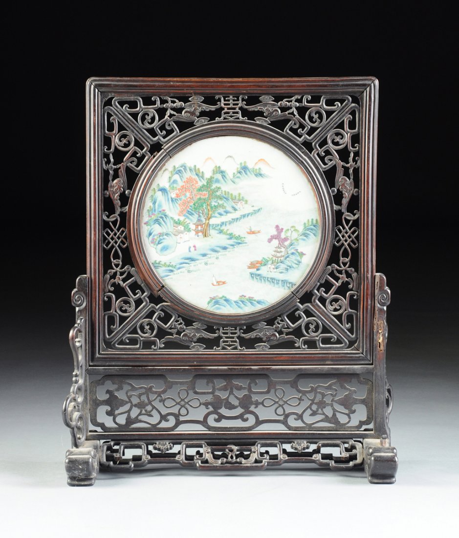 A CHINESE LATE QING DYNASTY/EARLY REPUBLIC PERIOD: A CHINESE LATE QING DYNASTY/EARLY REPUBLIC PERIOD CARVED ROSEWOOD TABLE SCREEN MOUNTED WITH A CIRCULAR FAMILLE VERTE PORCELAIN PLAQUE, PROBABLY JINGDEZHEN, CIRCA 1910-1920, the screen with removable c