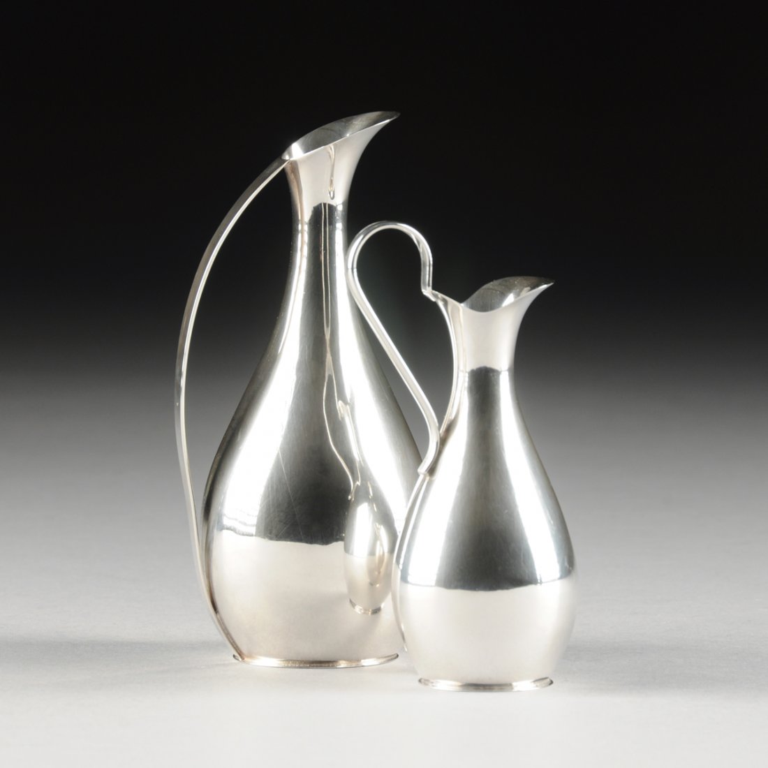 A SET OF TWO HENRIK FOGH MINIATURE STERLING SILVER: A SET OF TWO HENRIK FOGH MINIATURE STERLING SILVER PITCHERS, GLOSTRUP, DENMARK, CIRCA 1980, comprising two miniature models based on Kay Otto Fisker's sterling silver water pitchers originally produce