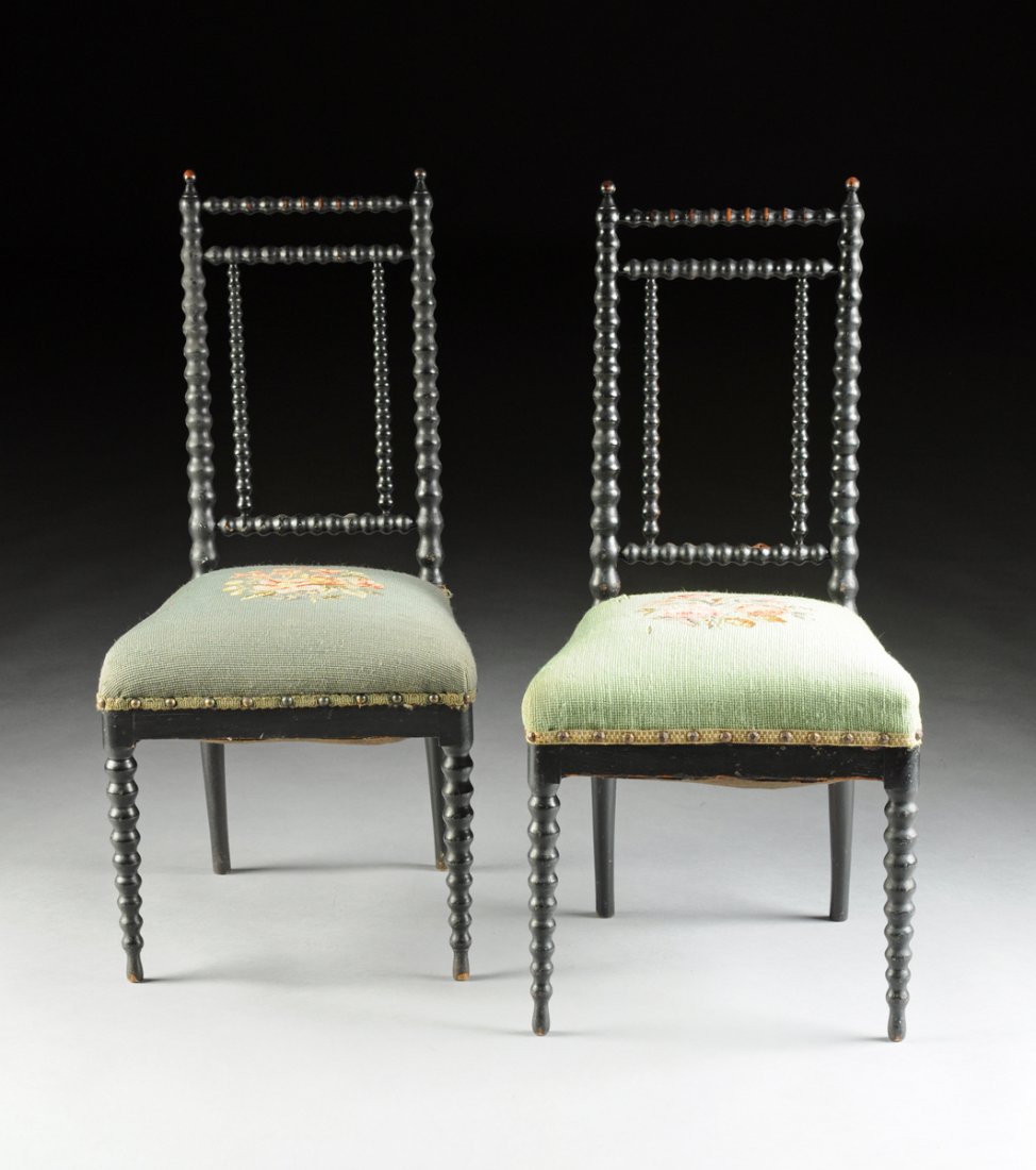 A PAIR OF DIMINUTIVE VICTORIAN EBONIZED AND CARVED WOOD: A PAIR OF DIMINUTIVE VICTORIAN EBONIZED AND CARVED WOOD SIDE CHAIRS, THIRD QUARTER 19TH CENTURY, each with a rectangular open back splat of turned wood stiles, on a trapezoidal seat with a circular po