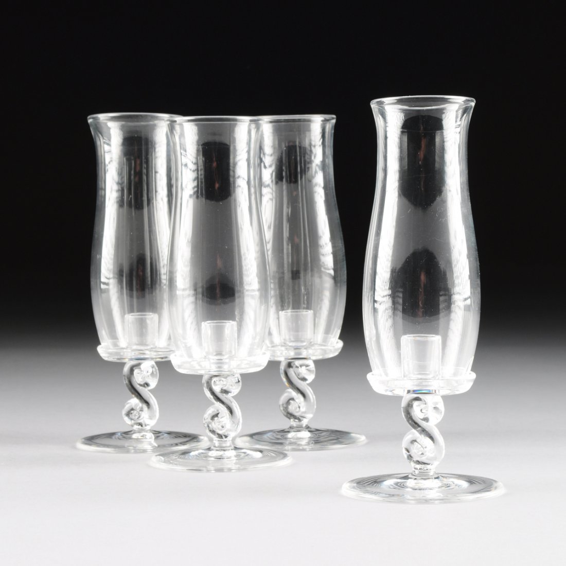 A SET OF FOUR STEUBEN CRYSTAL CANDLE LAMPS, DESIGNED BY: A SET OF FOUR STEUBEN CRYSTAL CANDLE LAMPS, DESIGNED BY ARTHUR DOUGLAS, ENGRAVED SIGNATURE, PATTERN NUMBER 7866, THIRD QUARTER 20TH CENTURY, each modeled with a cylindrical nozzle on a shallow dish fo