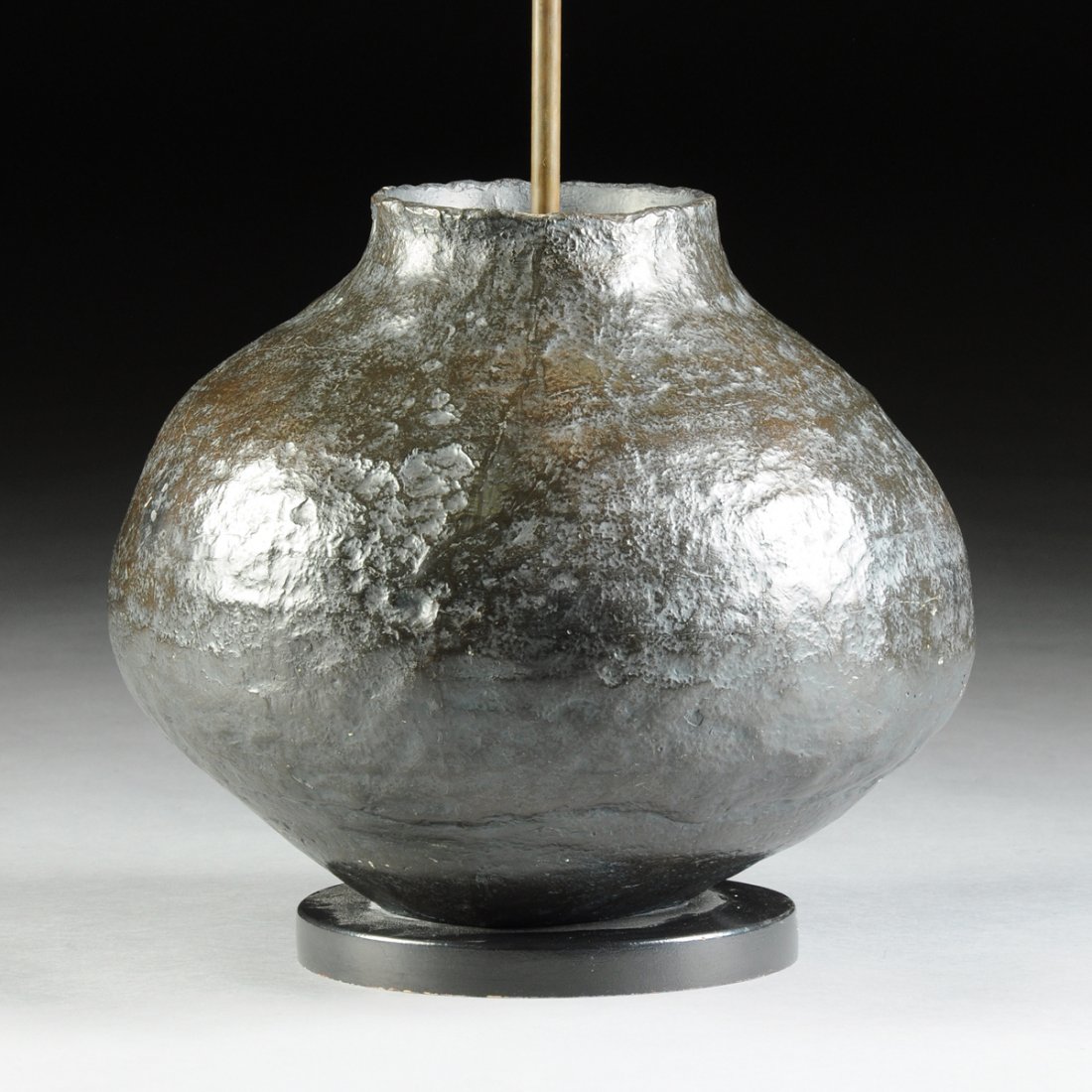 A BRUTALIST POD FORM PATINATED PLASTER TABLE LAMP,: A BRUTALIST POD FORM PATINATED PLASTER TABLE LAMP, PROBABLY AMERICAN, CIRCA 1960, of asymmetrical rounded form with tooled and patinated ground, on black painted wooden base. Height: 28 1/2" Diameter: