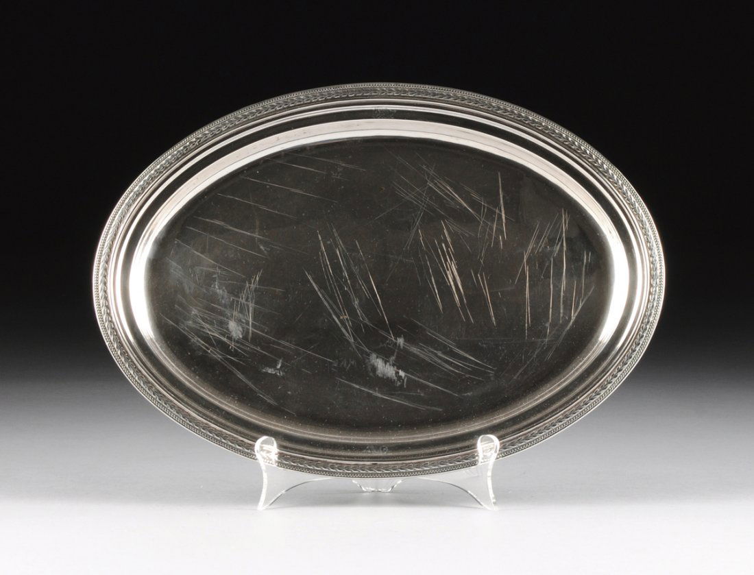 A TIFFANY & CO. STERLING SILVER OVAL TRAY, MADE BY JOHN: A TIFFANY & CO. STERLING SILVER OVAL TRAY, MADE BY JOHN C. MOORE & SON, NEW YORK, NEW YORK, CIRCA 1869-1870, with laurel leaf and beaded border, the inner border with engraved dophin crests, marks: "T