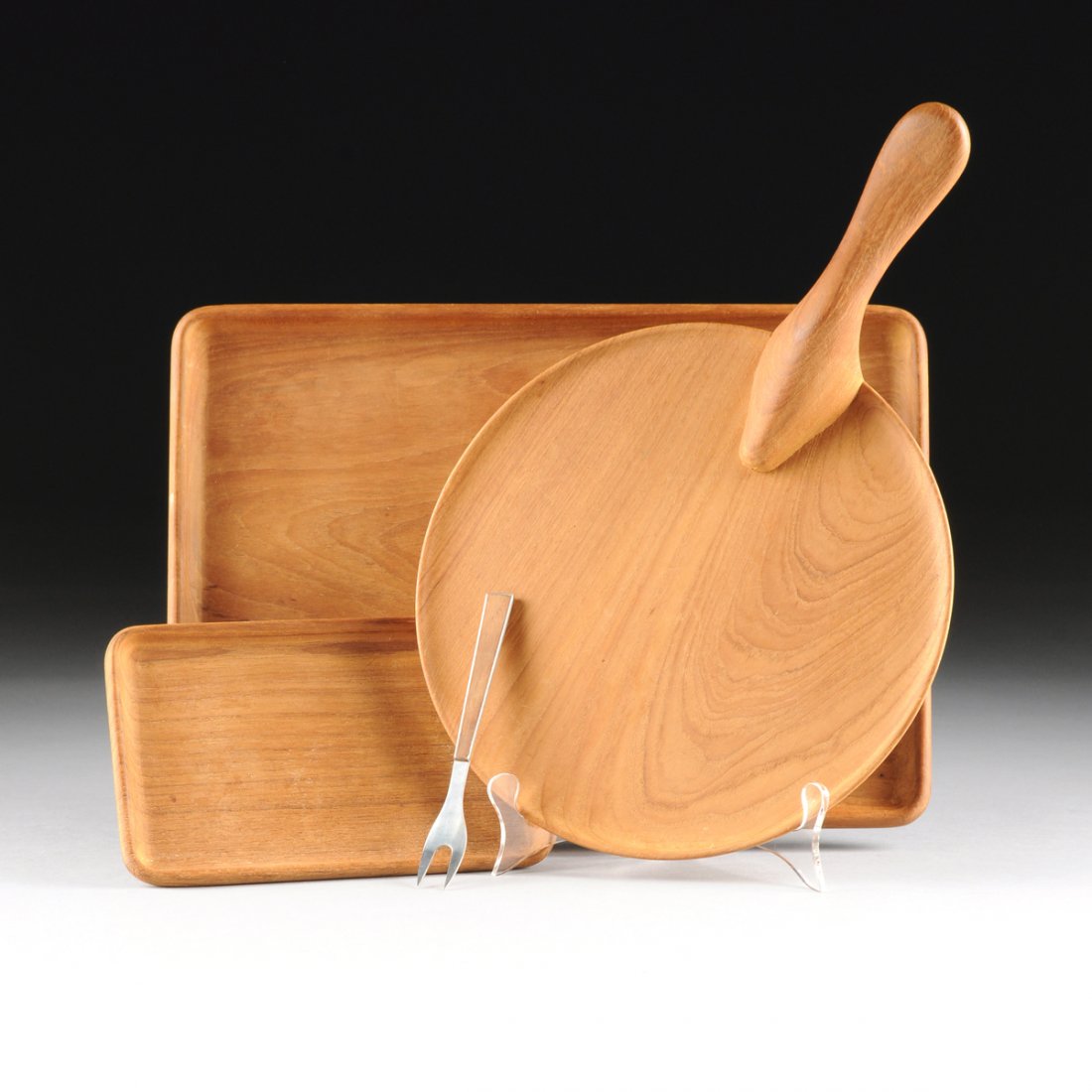 KAY BOJESEN (Danish 1886-1958) A GROUP OF FOUR CARVED: KAY BOJESEN (Danish 1886-1958) A GROUP OF FOUR CARVED TEAK WARES, STAMPED, CIRCA 1955, each stamped on reverse, "KAY BOJESEN / COPYRIGHT / DENMARK," comprising a circular cheese platter with handle, l