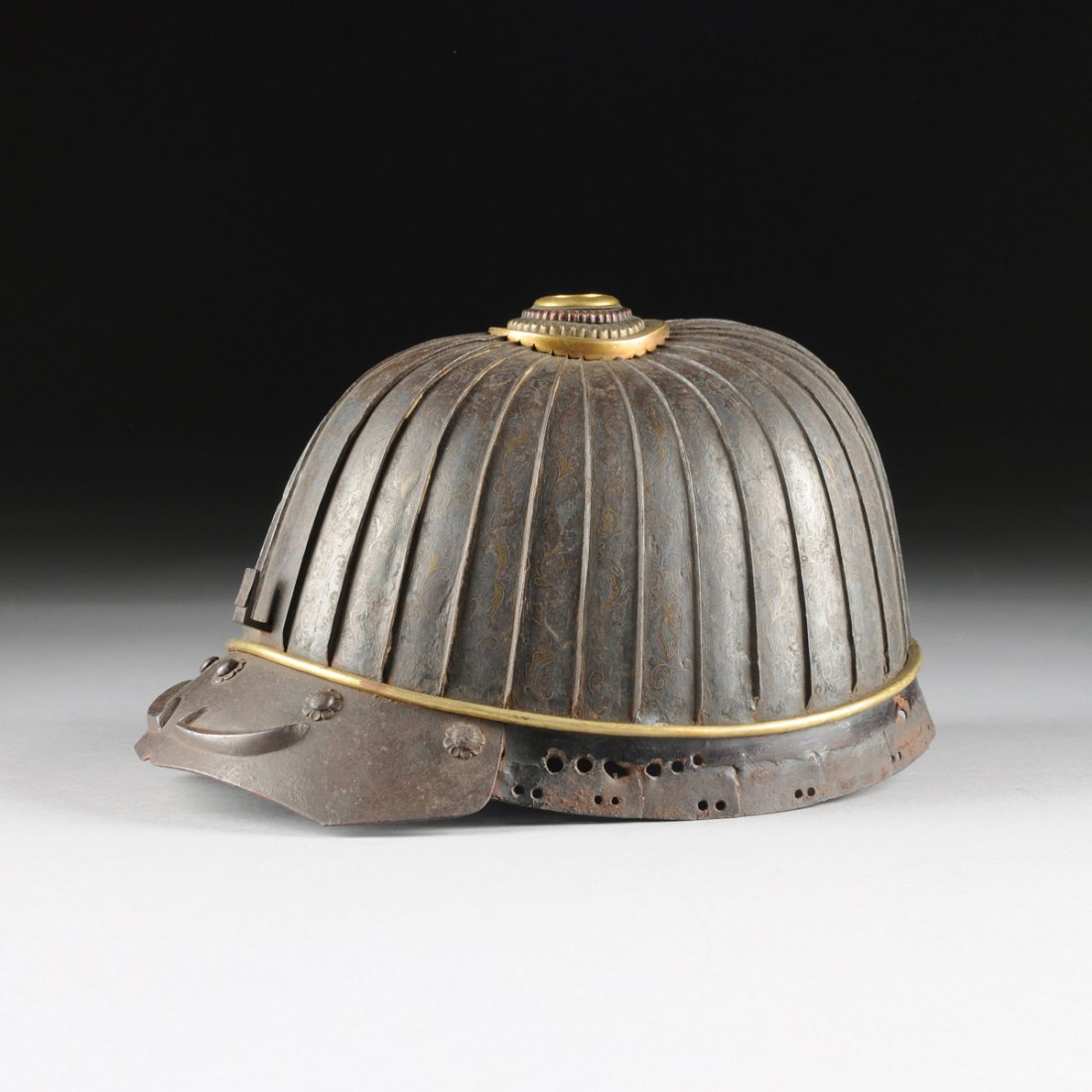 A JAPANESE GILT AND SILVERED METAL MOUNTED IRON KABUTO: A JAPANESE GILT AND SILVERED METAL MOUNTED IRON KABUTO HELMET, CIRCA 1700, of shaped domed form and vertical bands centering delicate scrolling silver and gilt wire floral inlay on a finely cross-hatc