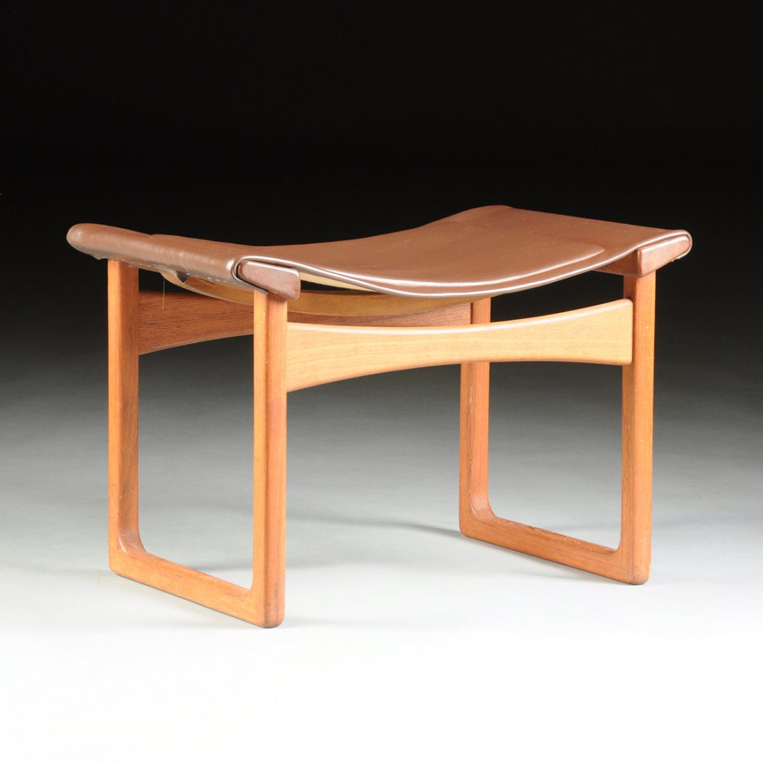 EJNAR LARSEN (Danish 1917-1987) AND AKSEL BENDER MADSEN: EJNAR LARSEN (Danish 1917-1987) AND AKSEL BENDER MADSEN (Danish 1916-2000) A TEAK FOOTSTOOL WITH LEATHER UPHOLSTERY, FOR LUDVIG PONTOPPIDAN, COPENHAGEN, DENMARK, CIRCA 1955, the teak frame suspending