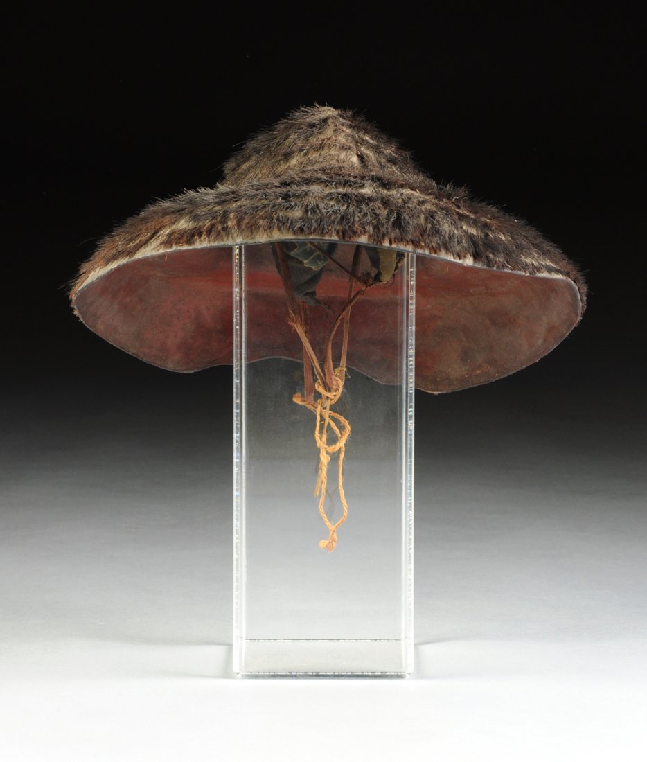 A JAPANESE BEAR SKIN COVERED SAMURAI HAT, LATE: A JAPANESE BEAR SKIN COVERED SAMURAI HAT, LATE 19TH/EARLY 20TH CENTURY, of shaped circular form with a oval domed helmet shaped top above tapering rounded sides and a flat back, reversing to a red lac