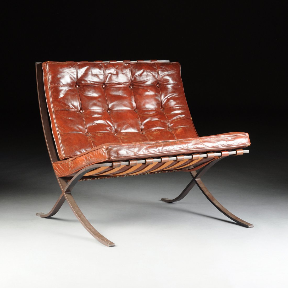 MIES VAN DER ROHE (German 1886-1969) A PAIR OF: MIES VAN DER ROHE (German 1886-1969) A PAIR OF PATINATED STEEL AND LEATHER "BARCELONA CHAIRS," FOR KNOLL, NEW YORK, NEW YORK, DESIGNED 1929, PRODUCED CIRCA 1955, the black anodized steel "X" frame cha