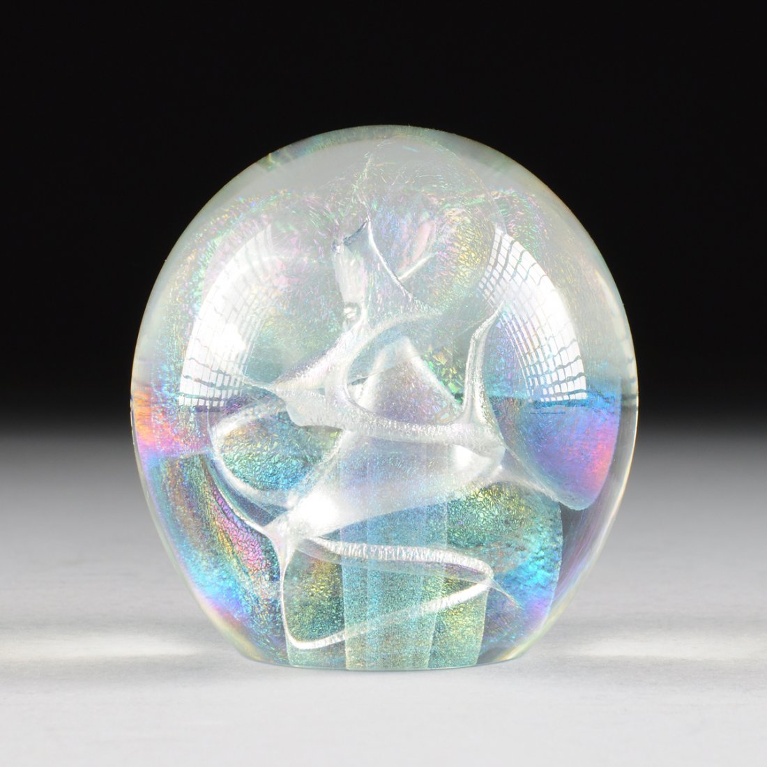 ROBERT W. STEPHAN (AMERICAN 20TH CENTURY) ART GLASS: ROBERT W. STEPHAN (AMERICAN 20TH CENTURY) ART GLASS PAPERWEIGHT, ENGRAVED SIGNATURE, 1987, of spherical form and enclosing internal swirling iridescent air pockets, reversing to a flat base centering 