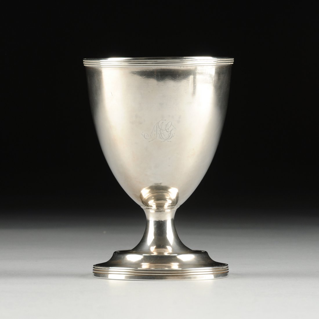 A GEORGE III STERLING SILVER GOBELET, HALLMARKED,: A GEORGE III STERLING SILVER GOBELET, HALLMARKED, SILVERSMITHS PETER AND ANN BATEMAN, LONDON, 1778, with a circular reeded rim on tapering sides centering an engraved monogram and raised on a conformi