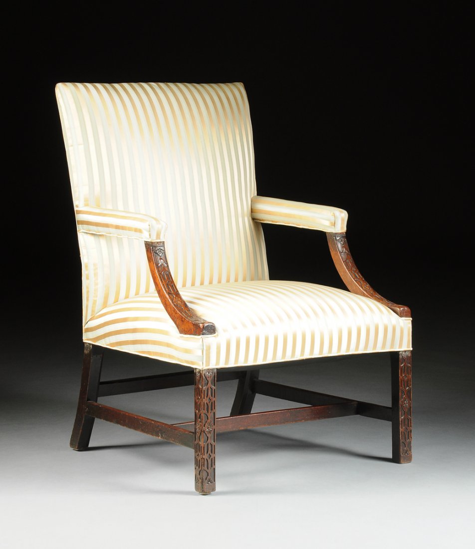 A GEORGE III MAHOGANY LIBRARY ARMCHAIR, MID 18TH: A GEORGE III MAHOGANY LIBRARY ARMCHAIR, MID 18TH CENTURY, in the manner of Thomas Chippendale (English 1718-1779), the rectangular padded back and seat covered in later pale green and gold silk stripe