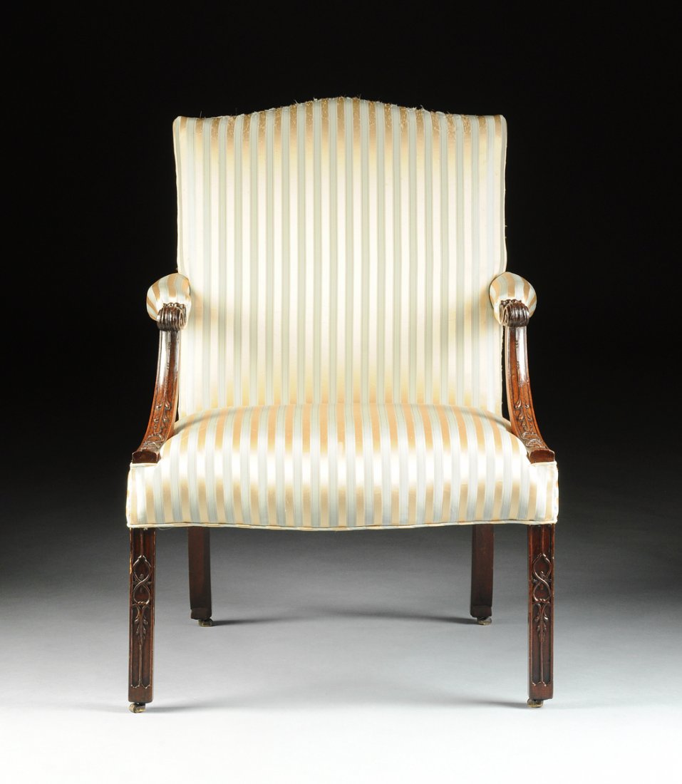 A GEORGE III MAHOGANY LIBRARY ARMCHAIR, MID 18TH: A GEORGE III MAHOGANY LIBRARY ARMCHAIR, MID 18TH CENTURY, in the manner of Thomas Chippendale (English 1718-1779), the rectangular padded back and seat covered in a later pale green and gold silk stri