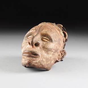 AN LATMUL NATURALISTICALLY OVERMODELED AND PAINTED: AN IATMUL NATURALISTICALLY OVERMODELED AND PAINTED HUMAN SKULL, MIDDLE SEPIK RIVER, PAPUA NEW GUINEA, EARLY 20TH CENTURY, the finely modeled clay covered skull with portrait like facial features flank