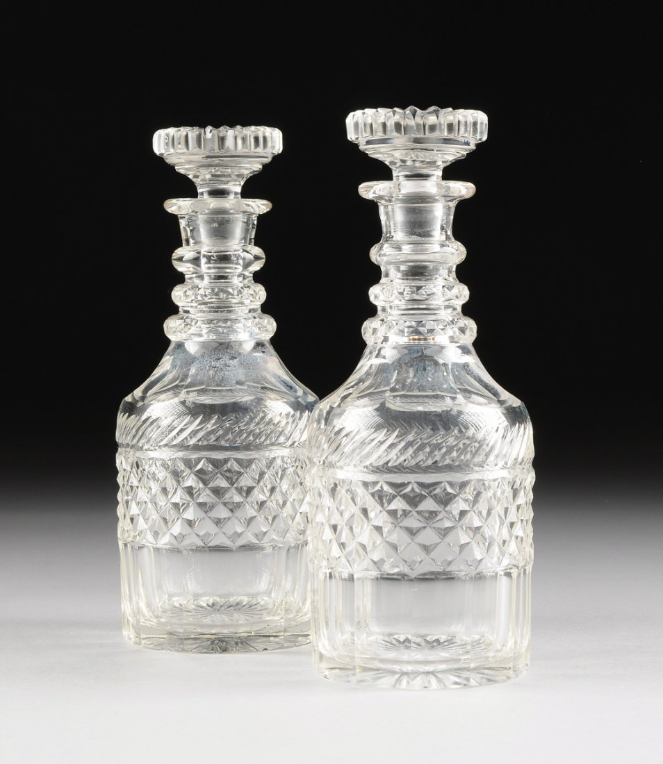 A PAIR OF GEORGIAN CUT GLASS MAGNUM "NELSON" DECANTERS,: A PAIR OF GEORGIAN CUT GLASS MAGNUM "NELSON" DECANTERS, FIRST QUARTER 19TH CENTURY, each with a solid wide pouring lip leading to a triple annulated neck and a high prism cut shoulder above the straig