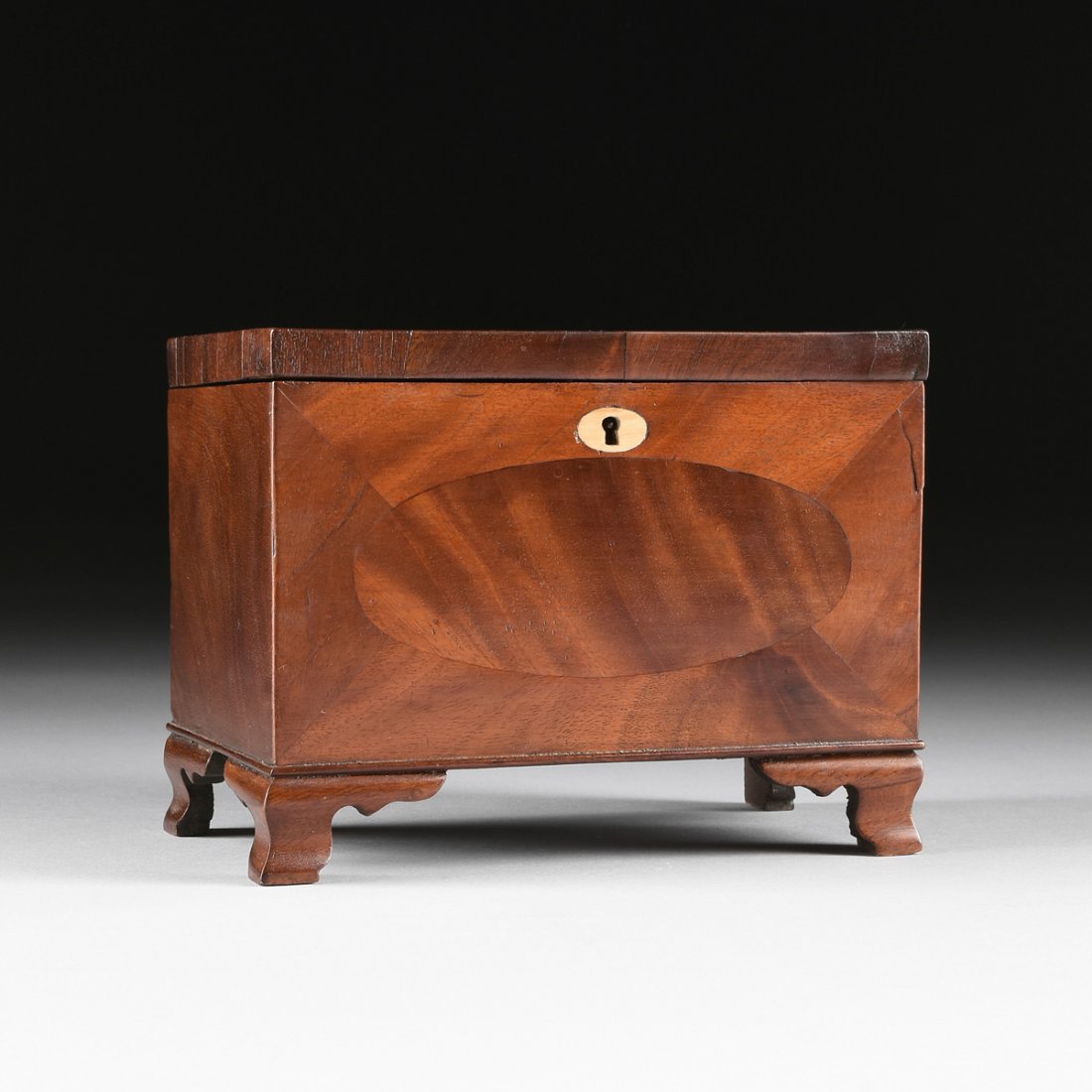 A FEDERAL MAHOGANY PARQUETRY KEEPSAKE BOX, DATED 1824,: A FEDERAL MAHOGANY PARQUETRY KEEPSAKE BOX, DATED 1824, the rectangular hinged lid above conforming sides and the front centering an oval bone escutcheon over an oval inlaid flame mahogany panel, rever