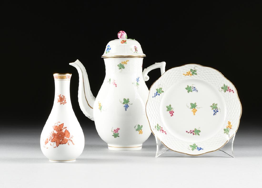 A GROUP OF THREE HEREND PORCELAIN MANUFACTORY: A GROUP OF THREE HEREND PORCELAIN MANUFACTORY POLYCHROME ENAMEL TABLE WARES, HEREND, HUNGARY, CIRCA 1940 AND 1976, comprising a plate with basket weave border with hand colored transfer printed grape