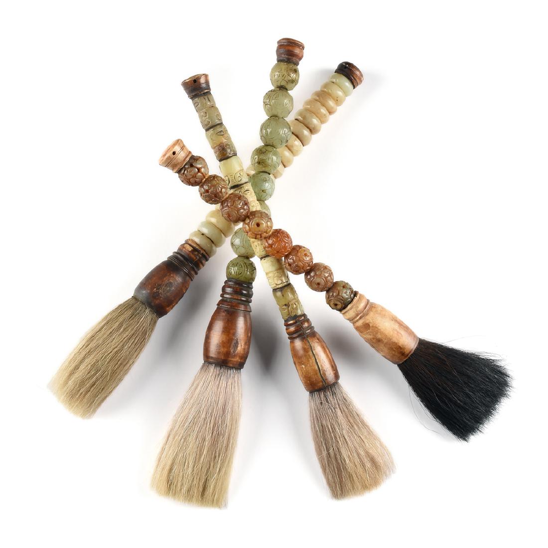 A GROUP OF FOUR SOUTH EAST ASIAN CALLIGRAPHY BRUSHES,: A GROUP OF FOUR SOUTH EAST ASIAN CALLIGRAPHY BRUSHES, 20TH CENTURY, comprising a brush with eight carved and stained jadeite beads and stained bone terminal and ferrule; length: 15 1/2"; a brush with 