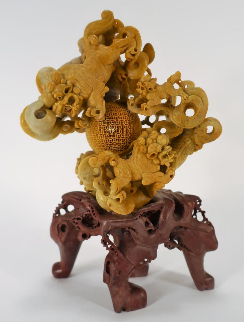 Chinese Carved Soapstone Centerpiece w Dragons: Chinese Carved Soapstone Two Part Centerpiece with seven foo lions, large and small; astride a hollowed and pierced sphere; its base a wine/maroon toned four footed biomorphic form. (RLEV5000) (TC) Di