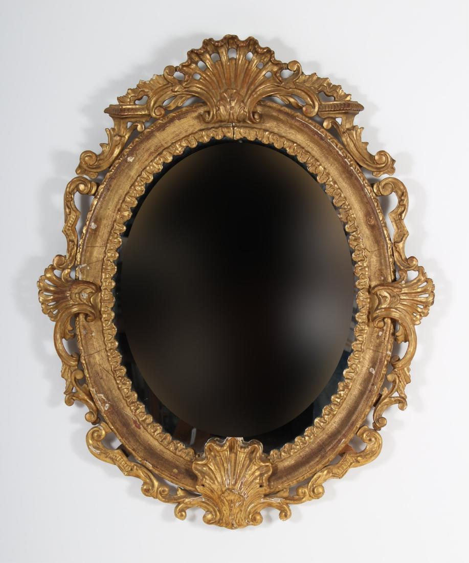 Italian Baroque Carved Giltwood Mirror, 17th c.: An Italian Baroque Heavily Carved Giltwood Mirror, possibly Venetian, with pierce-carved shells and arabesques, square pegging with old nails Dimensions: 41x33 overall, oval mirror plate 24x20 Propert