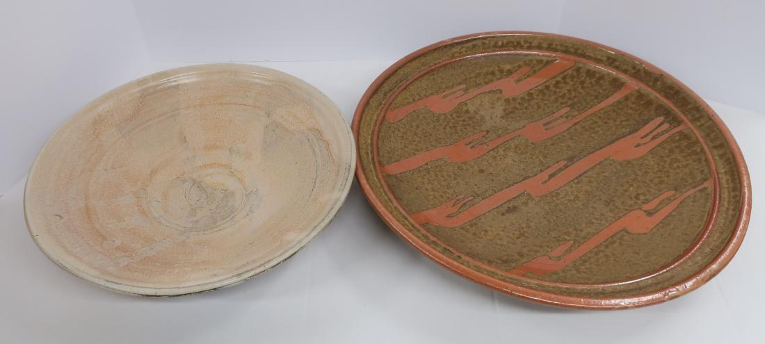 Two Art Pottery Platters: Goldberg, Twersky: Scott Goldberg, ( larger platter), signed on bottom, holes in base rim for wall hanging. Mottled, rougher, porous brown w/ rust/orange color,higher gloss glaze to rim bands and design. Jonathan Twersk