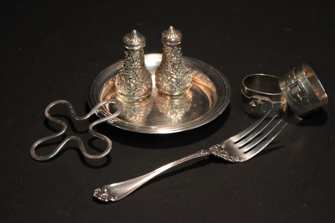 Small Lot of Sterling & Silverplate: Comprising: a Christofle wine coaster with quatrefoil insert, a pair of napkin rings, serving fork, all silverplate; and a pair of sterling silver salt and pepper urns. Weighable Silver: 2.75 ozt DIME
