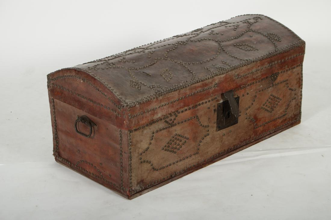 Red Leather Domed Trunk: Brass nail head decoration, 19th century or older, iron bail handles DIMENSIONS: 16" H x 35" L We encourage all bidders to obtain shipping quotes before placing bids. (QGMAL35-137) (WT)