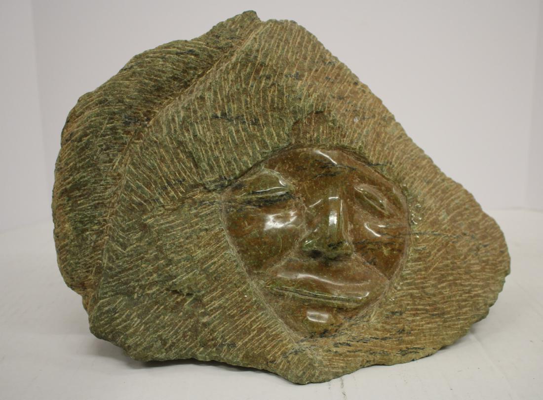 Stone Carving of Inuit Hooded Man: Inuit Hooded Man, carved stone, paper Co-Op label, signed beneath and possibly dated 1974 DIMENSIONS: 9.5" H x 14" W We encourage all bidders to obtain shipping quotes before placing bids. (NN4-269) (