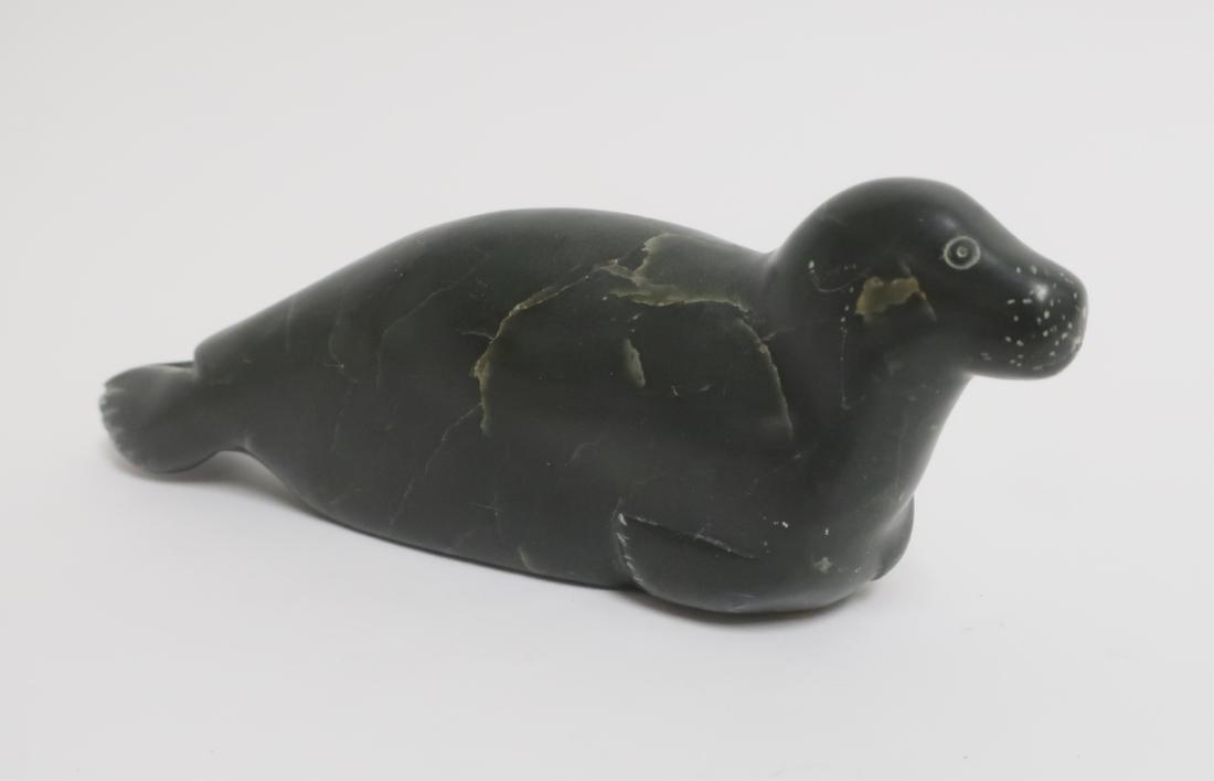 Carved Inuit Eskimo Sea Lion: Dartk green marble, veining to stone; shaped features , incised lines. Etched number and a paper label(Canada Eskimo Art) underside. 7.25"L