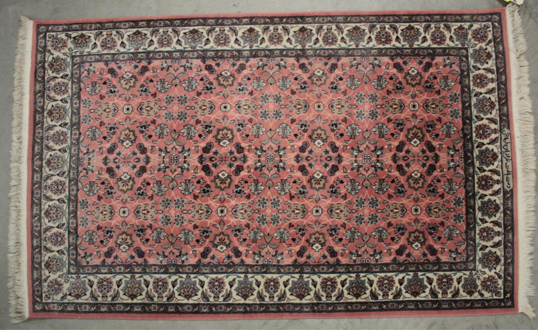 Persian Hand Knotted Wool Rug Inscribed: Persian Hand Knotted Wool Area Rug with Arabic inscription along field border, field with a rose colored ground, floral sprays in off white and tan and black accents, border with off white ground with
