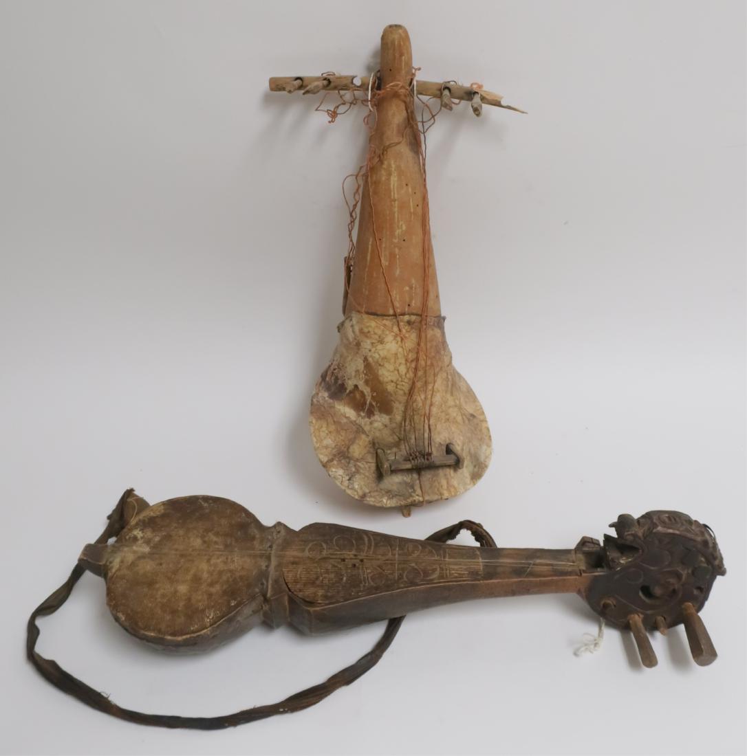 Two Vintage Ethnic Style Instruments: Carved wood,hide, traces of hide hair, nails, striped fabric sling/strap (possibly Nepal). Second: Fitted plant gourds, hide, fabric. Replacement stringing. Both as is. 18" and 20" CAPS5461/2 JP