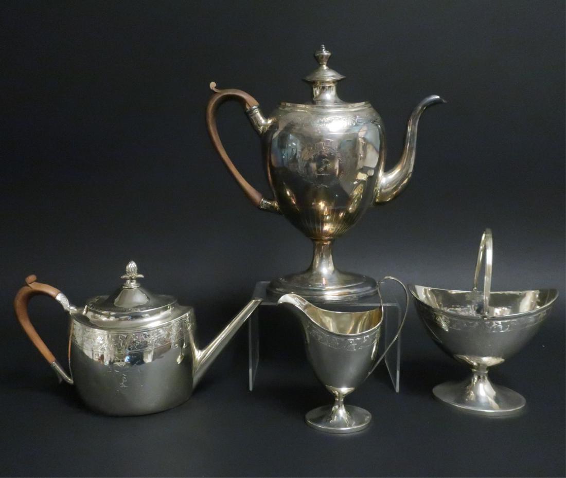 George III Silver Assembled Tea & Coffee Service: Comprising the following from Edinburgh, 1975: teaport with wood handled and pineapple finial, cream jug, sugar bowl. Each engraved with a grapevine border and a crest within a shield surrounded by a 