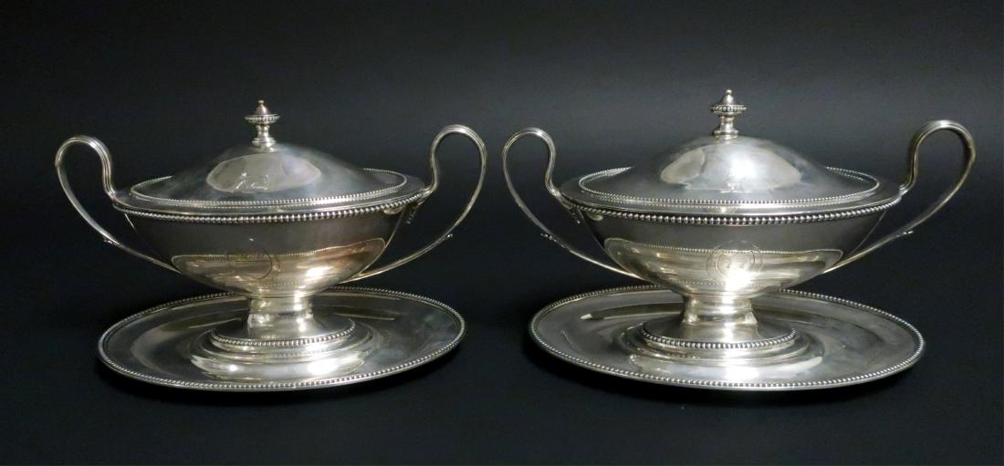 Pair George III Silver Covered Tureens on Stands: By Richard Carter, Daniel Smith & Robert Sharp, London, 1782. Each oval with beaded rims and two leafy handles, the covers with urn finials, the bowls engraved with two sheild-form reserves, the cover