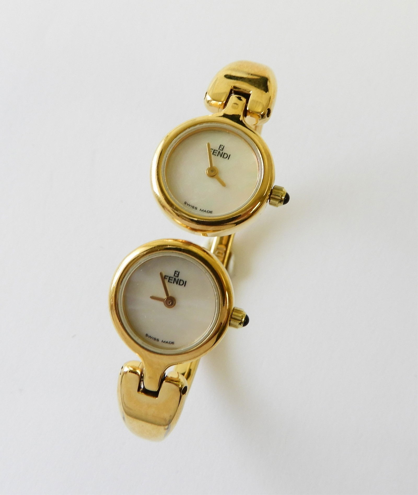 Fendi Double Face Lady's Wrist Watch: Double Mother of Pearl face, bangle style band. # 000160-620L. Swiss made quartz movement. 12.75 mm faces. Property from the estate of Jo Sullivan Loesser