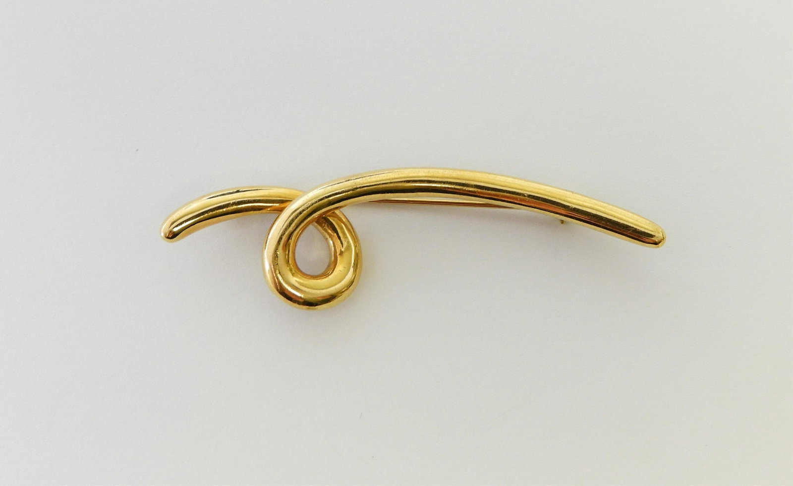 Angela Cummings 18K Yellow Gold Brooch: Loop scrolled design, stamped 1990 Cummings 18K on back. 2.5" long. 12.6 grams. Property from the estate of Jo Sullivan Loesser