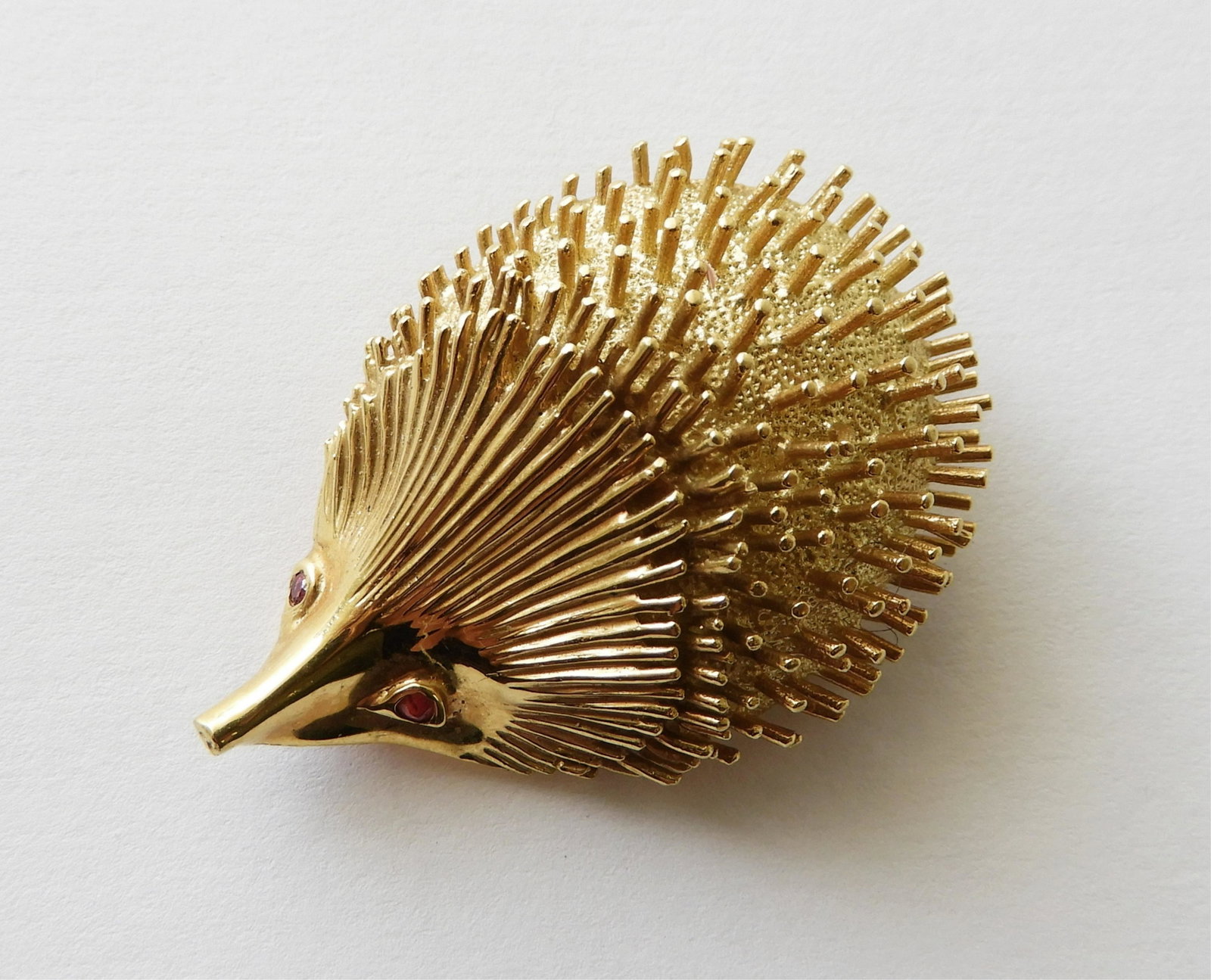 18K Yellow Gold Hedgehog Brooch: Enhanced with small ruby eyes. Back of brooch stamped 18K and numbered 987. 2" long, 17.3 grams. Property from the estate of Rosalie Coe Weir