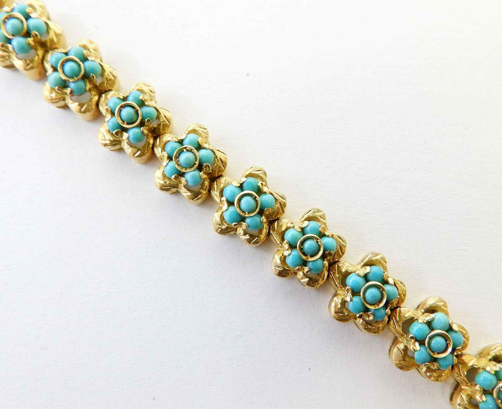 18K Yellow Gold & Turquoise Tennis Bracelet: 7.5" tennis bracelet with 22 links, each containing 6 cabochon turquoise in floral shape, set in 18k yellow gold. Stamped 750 with a second illegible stamp. Gross weight of 30.9 grams. Property from t