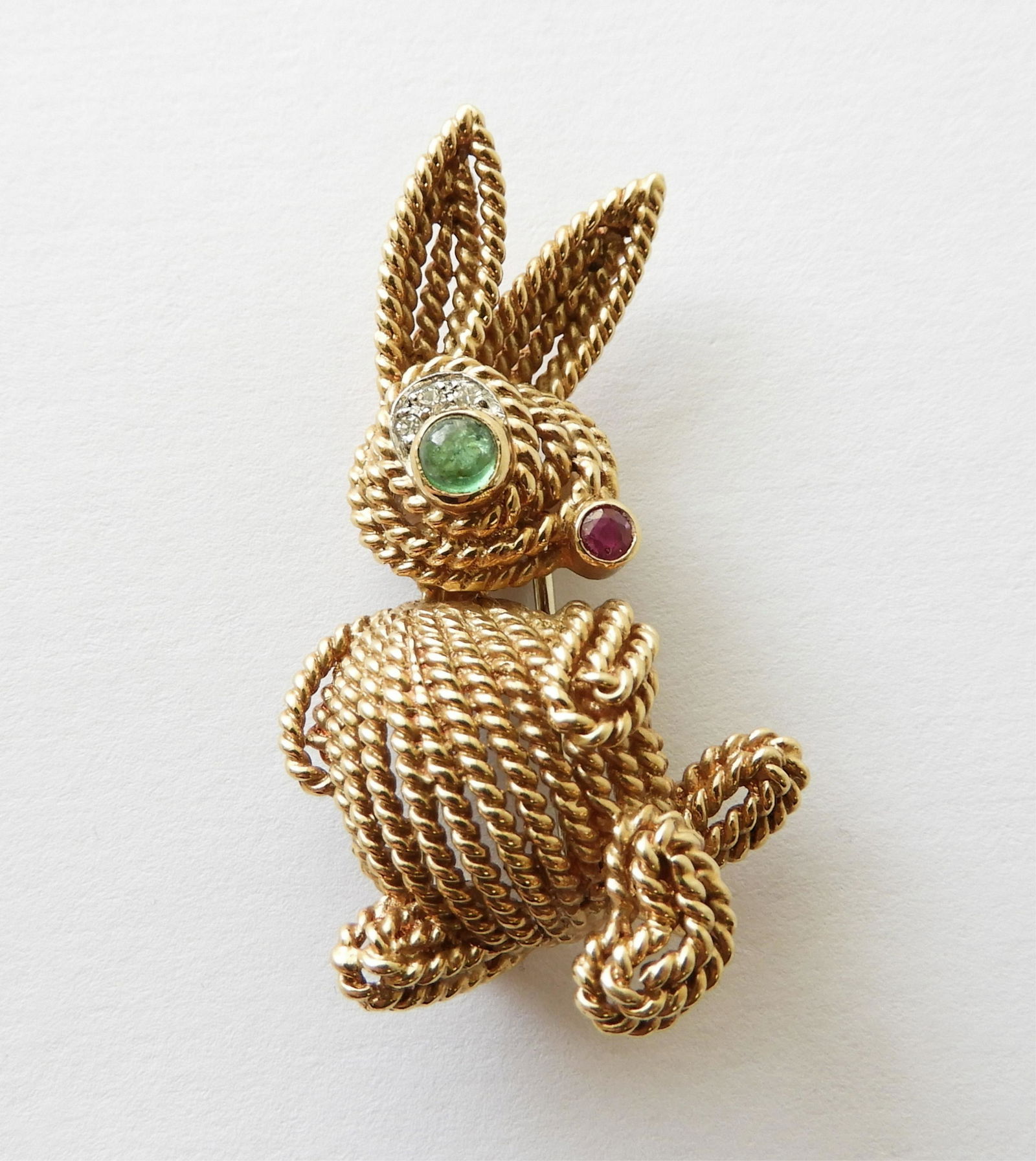 Van Cleef and Arpels - 18K Rabbit Brooch: - 1 Round cabochon emerald measures approximately 3.5mm diameter, set as eye - 1 Round faceted ruby measures approximately 2.0mm diameter; set as nose - 3 Round single cut diamonds weigh approximately
