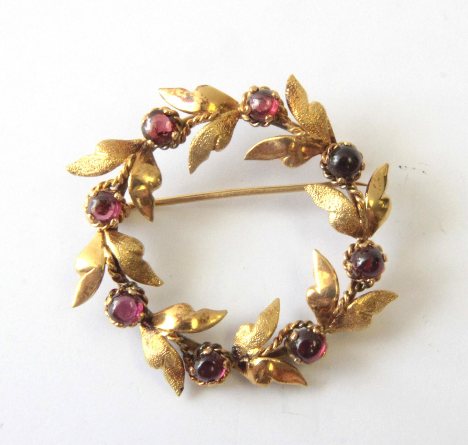 Garnet & 14K Open Circle Brooch: 8 Round cabochon garnets each measure approximately 4mm diameter, set in 14K yellow gold. 1.5" across. Gross weight of 8.9 grams. Property from the estate of Rosalie Coe Weir