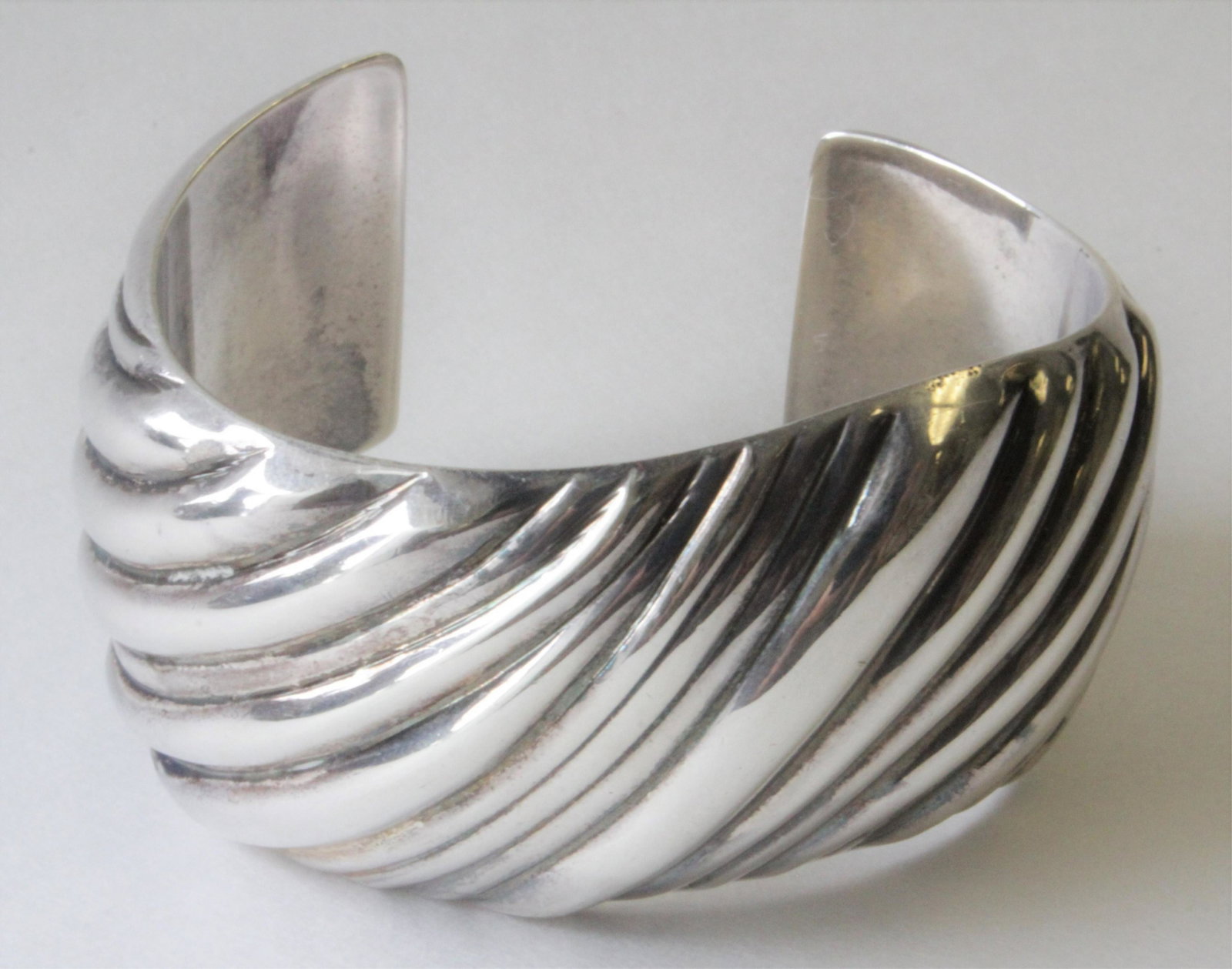 Tiffany & Co Sterling Silver Cuff Bracelet: Interior marked TIFFANY & CO ITALY * 540 FI 925. Exterior with abstract wave design. 2" interior diameter -- fits a smaller wrist size. Property from the estate of Ines Bausili