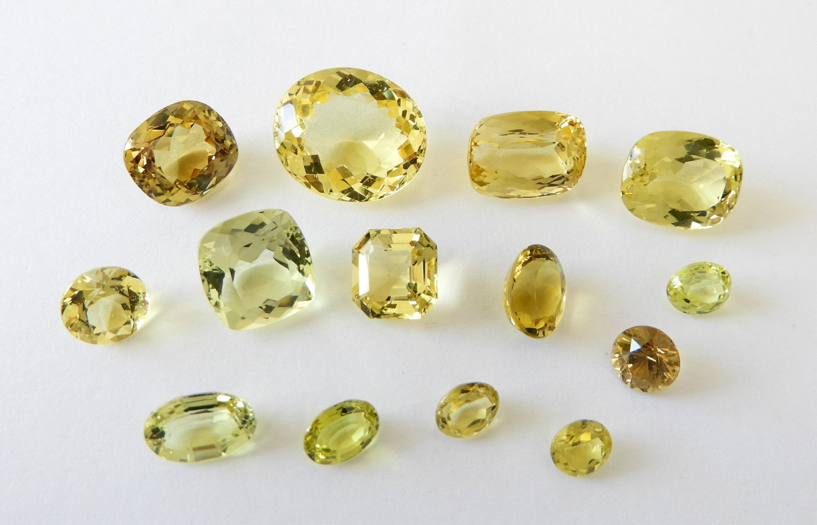 Group of Chrysoberyl & Golden Beryl - 54.48 TCW: - Oval faceted chrysoberyl, light green color. ~ 2.60ct - Oval faceted chrysoberyl, yellow green color. ~ 1.35ct - Oval faceted chrysoberyl, light green color. ~ 1.59ct - Cushion cut chrysoberyl, medi