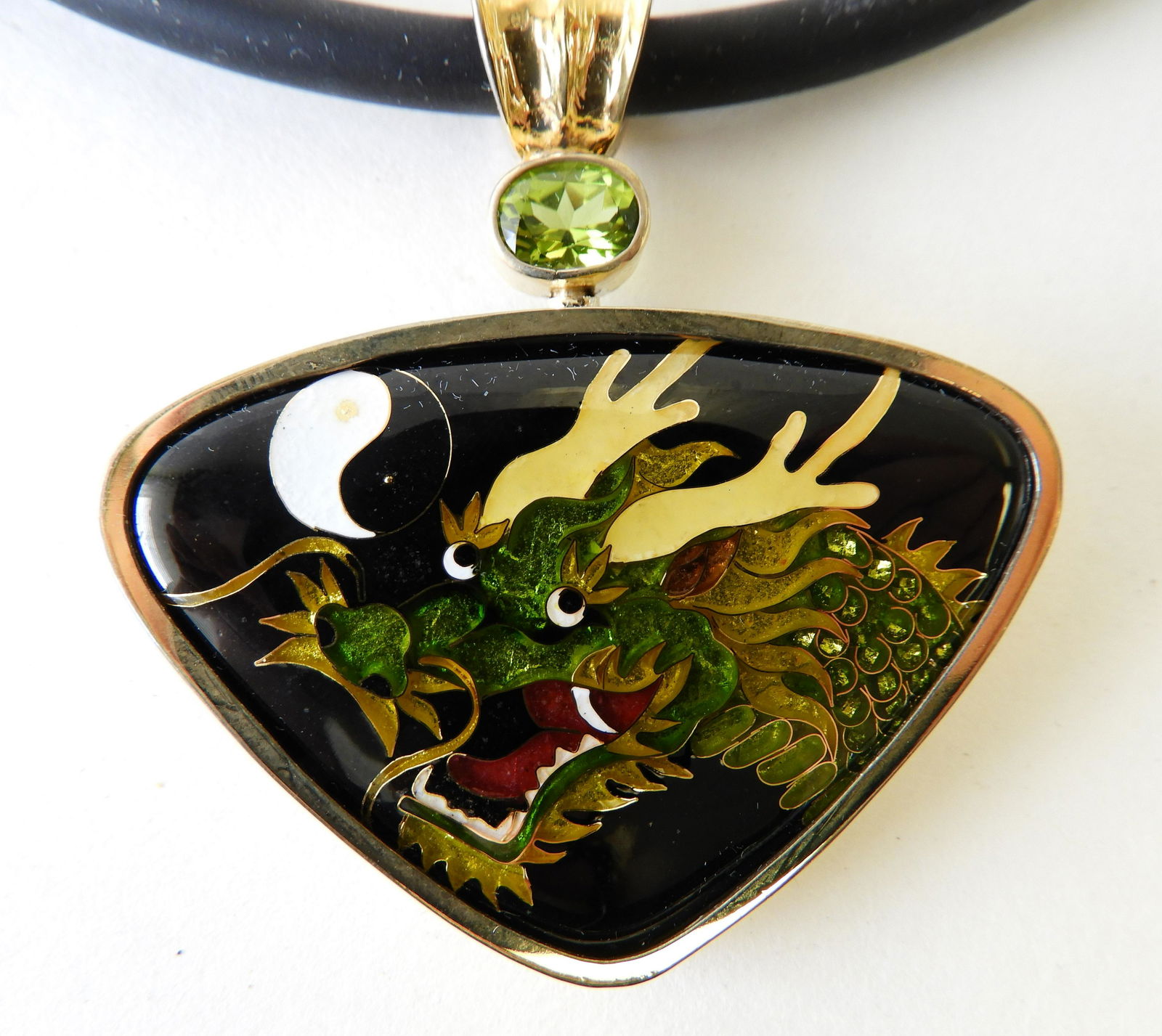 Cloisonne Enamel & 18k, Sterling Dragon Pendant: Pendant comprising of sterling silver and 18k yellow gold inset with a green and yellow cloisonne enamel dragon & yin and yang. Suspended from a black silicone choker, pendant measures 2" across. Stam